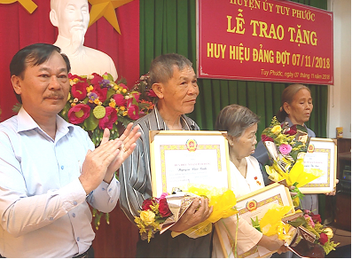 Đồng chí Nguyễn Văn Hùng- Phó Bí thư Thường trực Huyện ủy trao tặng Huy hiệu Đảng cho các đảng viên
