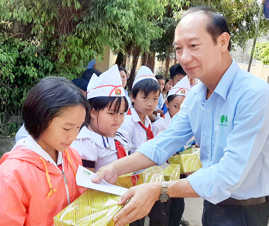 Đại diện lãnh đạo Công ty CP Phong điện Miền Trung tặng quà cho học sinh nghèo Trường TH Hòa Thắng vượt khó đến trường