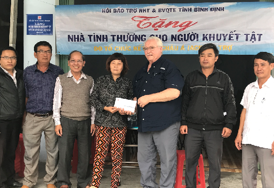 Ông John Dennis Havican- Chủ tịch Tổ chức ACI  trao tặng số tiền hỗ trợ xây dựng nhà tình thương cho bà Lê Thị Ngọc Ích, thôn Phú Mỹ 2, xã Phước Lộc