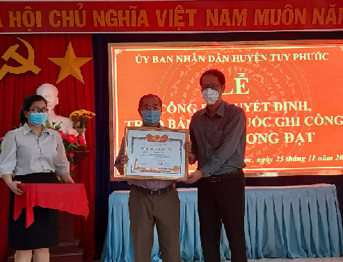 Đồng chí Nguyễn Hùng Tân -  Phó Chủ tịch UBND huyện trao Bằng Tổ quốc ghi công đến đại diện thân nhân liệt sĩ Trương Đạt