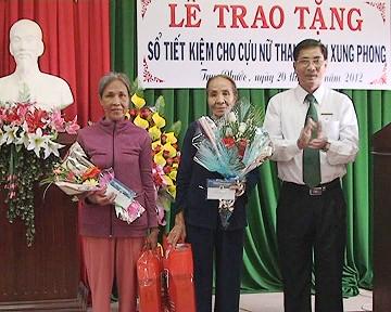 Ông Nguyễn Ngọc Chiến, Phó Giám đốc Chi nhánh Ngân hàng Nông nghiệp và Phát triển nông thôn huyện Tuy Phước trao tặng Sổ tiết kiệm cho cựu nữ TNXP