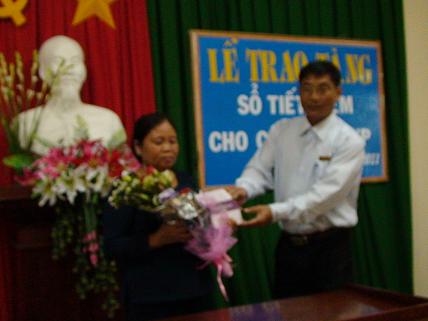 Đại diện lãnh đạo Ngân hàng NN&PTNT huyện trao tặng sổ tiết kiệm cho nữ thanh niên xung phong Huỳnh Thị Mười, ở Xã Phước Quang với sổ tiết kiệm trị giá 3 triệu đồng