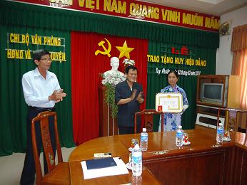 Đ/c Nguyễn Đình Huệ - Phó Bí thư Huyện ủy – Chủ tịch UBND huyện trao Huy hiệu 30 năm tuổi đảng cho đ/c Huỳnh Thị Thu Hương.