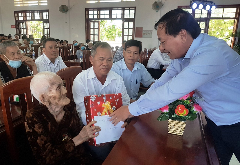 Đồng chí Nguyễn Văn Hùng - Tỉnh ủy viên, Bí thư Huyện ủy, Chủ tịch HĐND huyện tặng quà cho mẹ VNAH Tô Thị Hải ở xã Phước Sơn